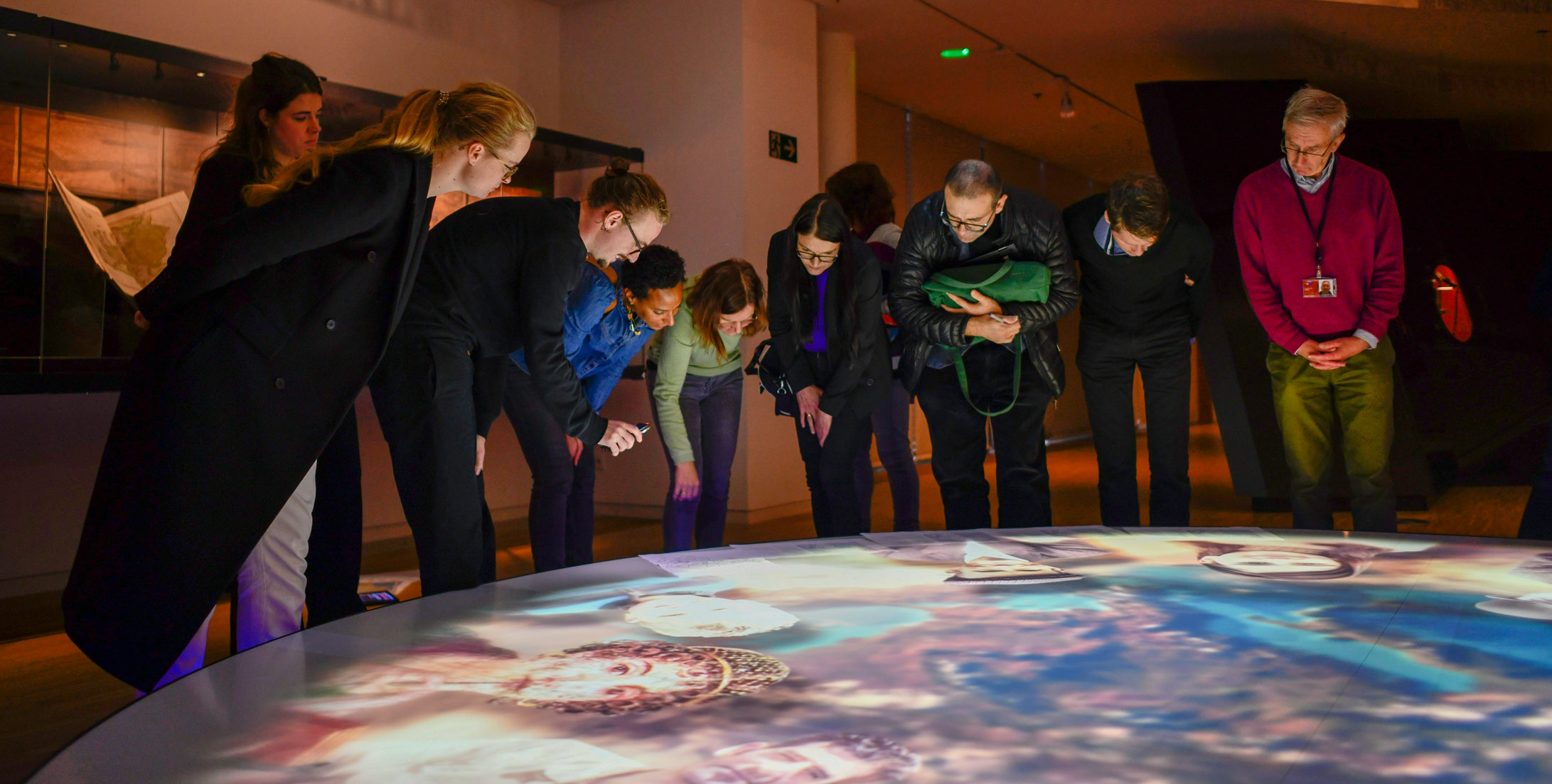 visitors looking at projected globe in museum
