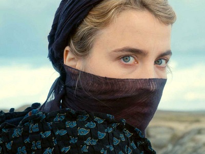 Woman with covered face looking in field