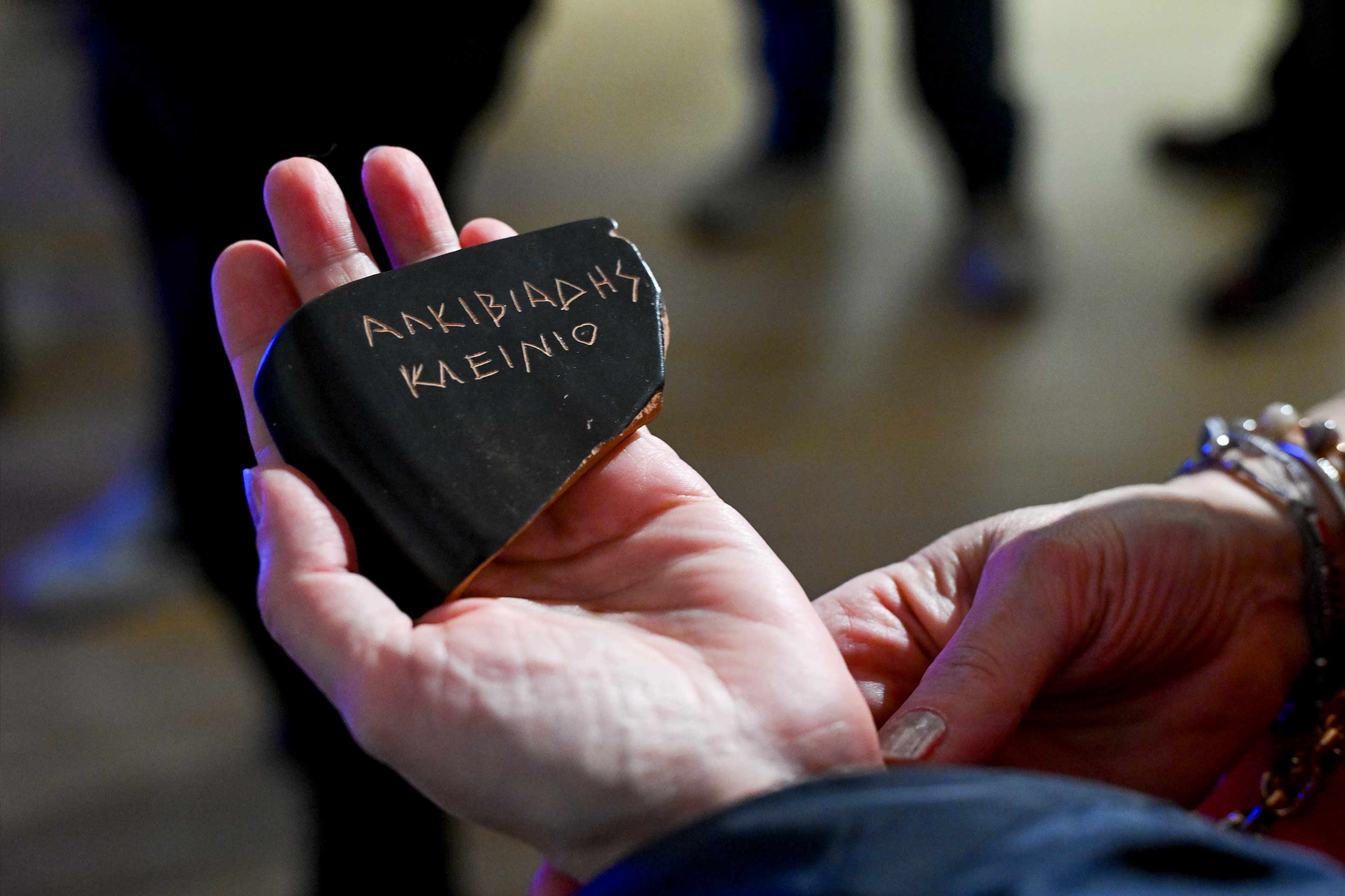 a hand holding a stone with text on it
