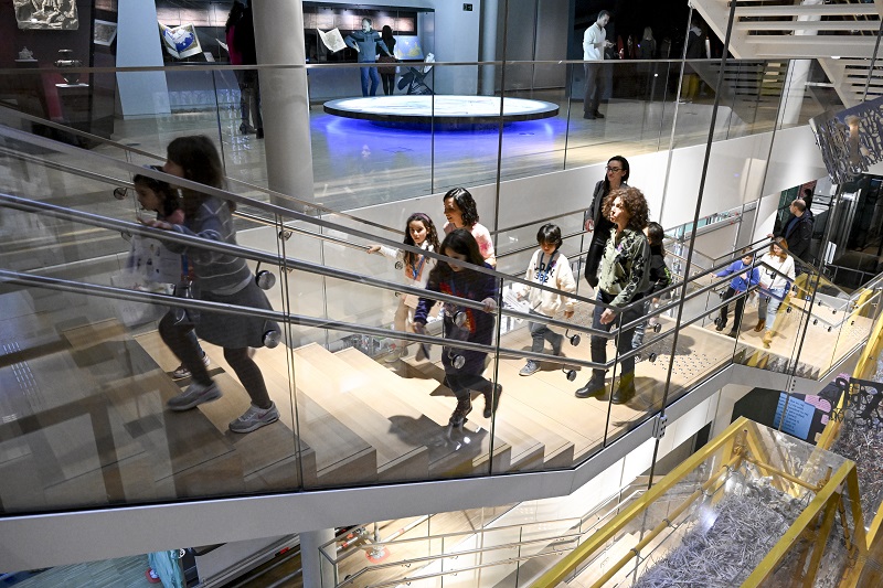 Family with kids walking up stairs in museum