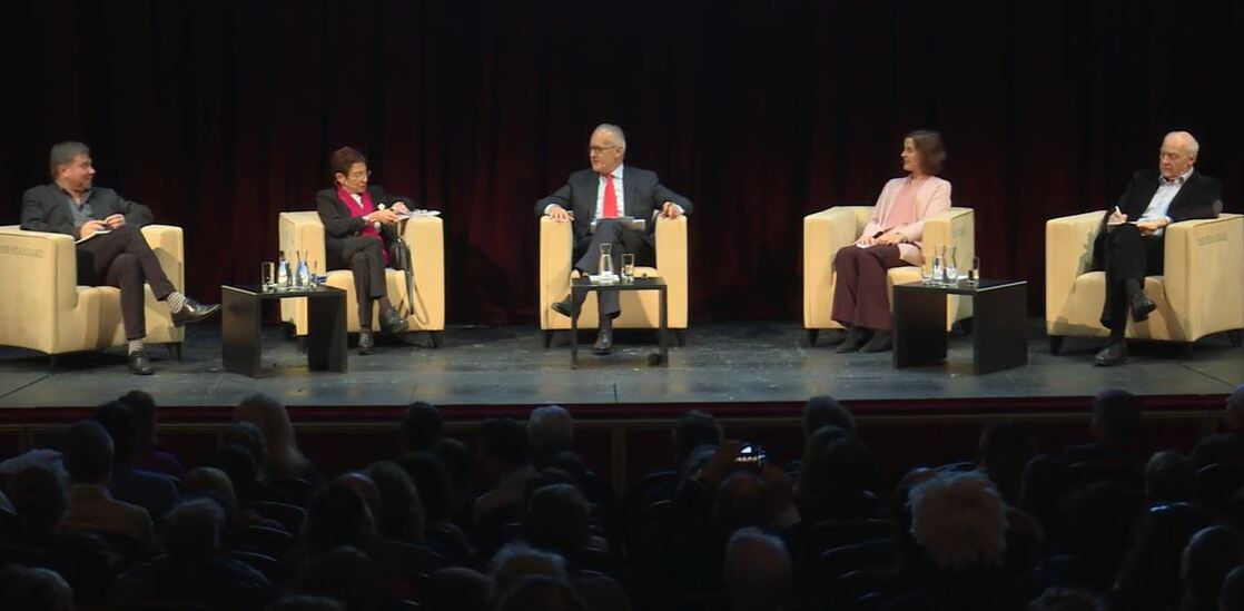 Deelnemers aan paneldebat op podium