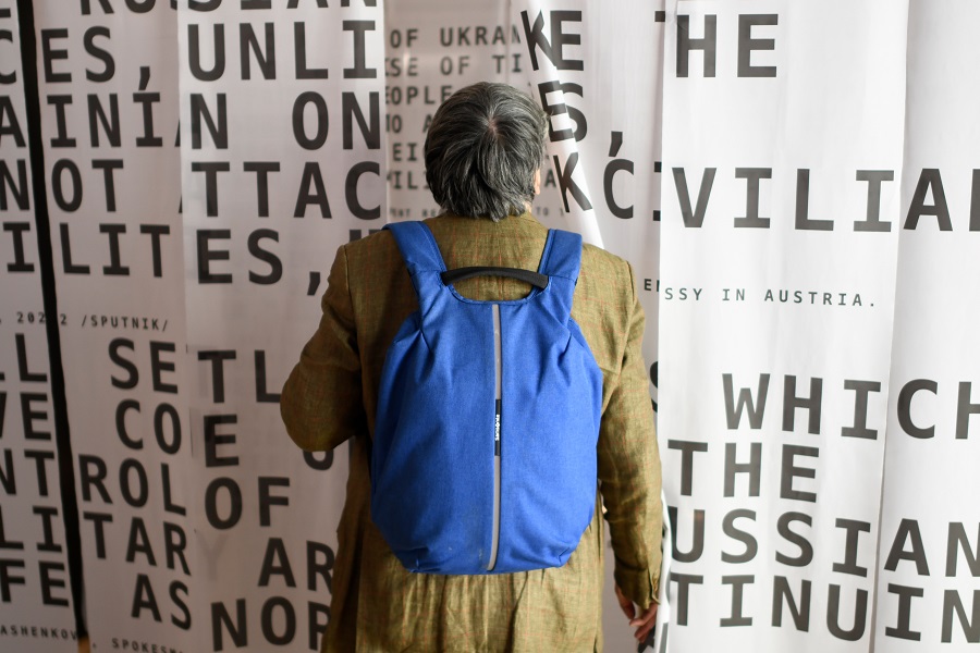 Person with backpack looking at propaganda wall