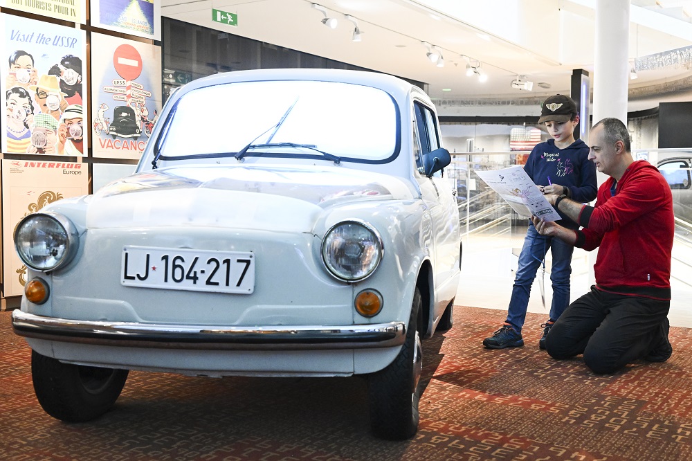 Man and child next to car in museum