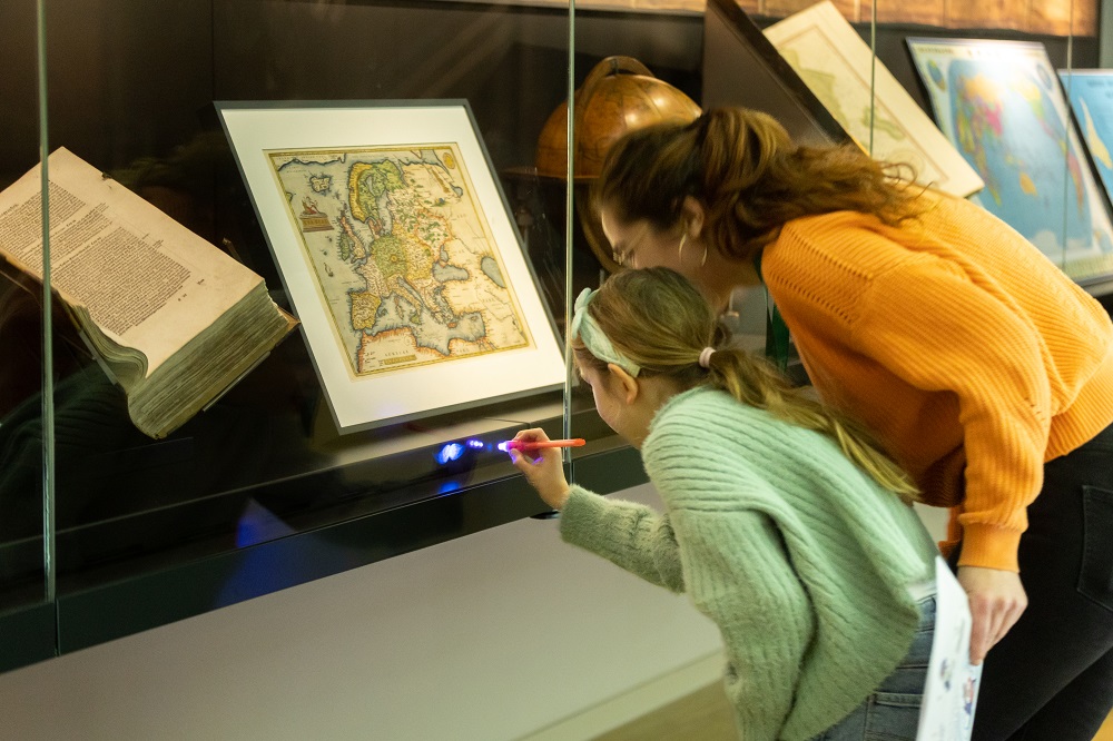Child and woman looking at museum showcase