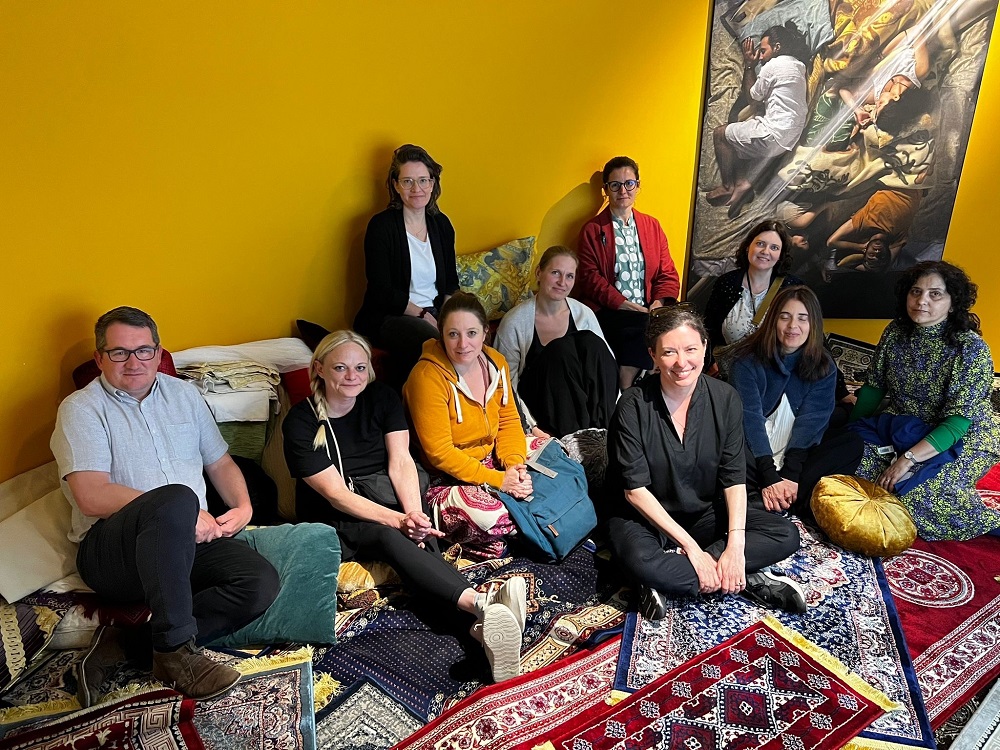 group sitting on carpet in exhibition