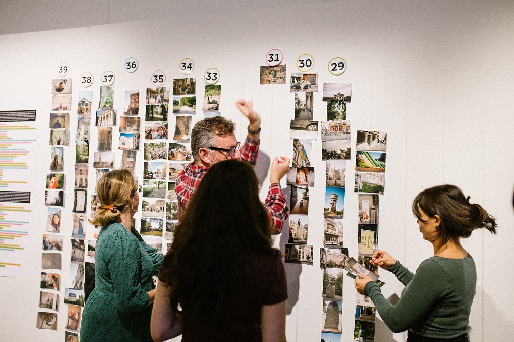 People adding photos to wall