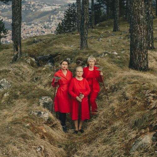 Drie vrouwen in het rood in het bos