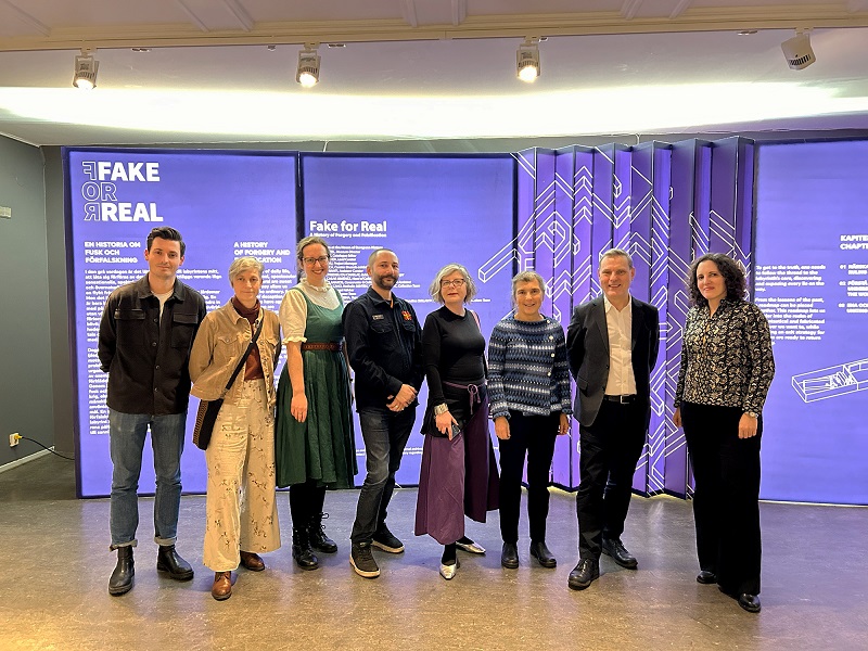 Men and women standing in front of purple background