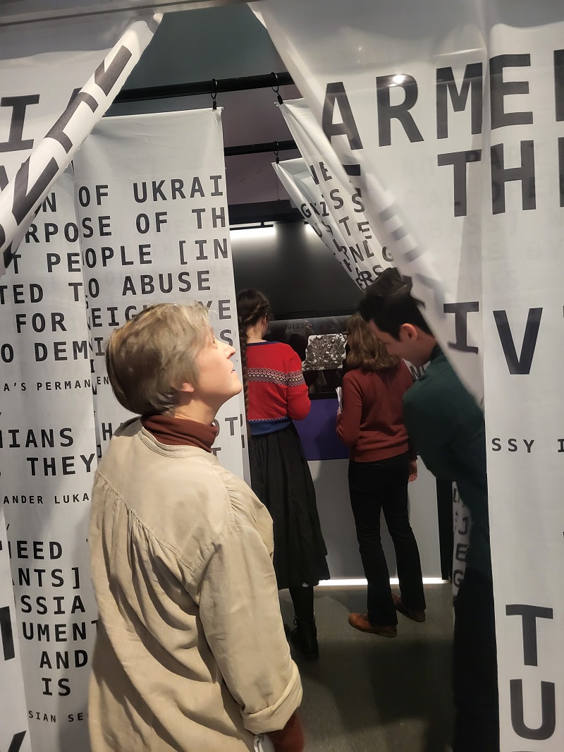 Visitors walking through print media curtains