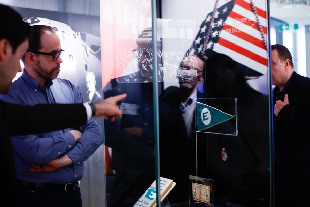 Men on museum tour looking at US flag