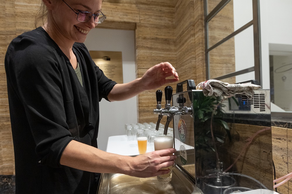 Woman pouring bear in bar area