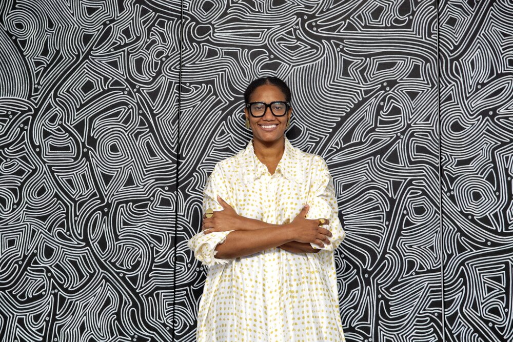 Woman standing in front of African art