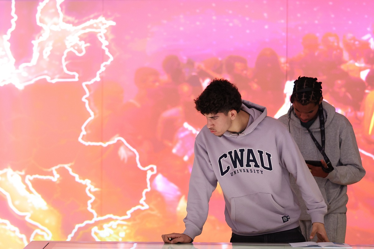 Two young people in front of museum projection
