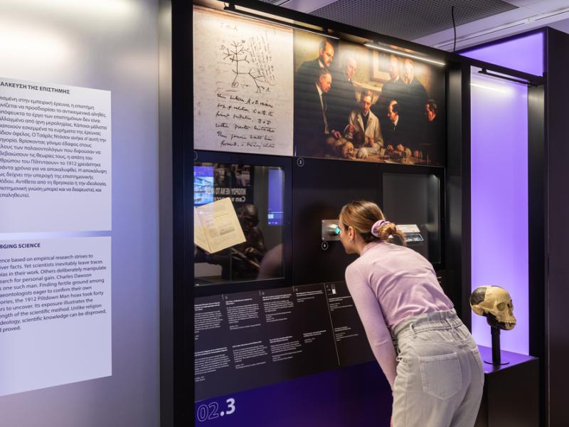 Woman looking through scope at exhibition