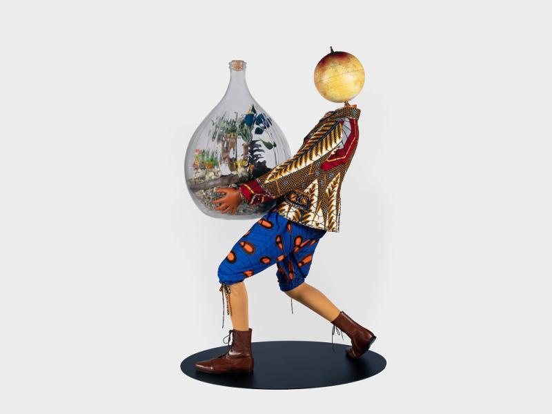 Wooden puppet figure carrying glass jar