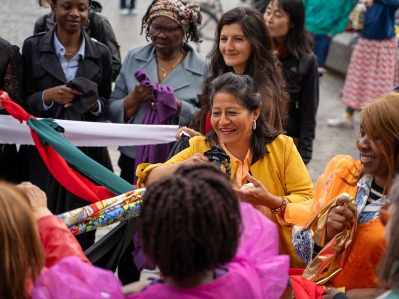 Woman in colourful jacket meeting people