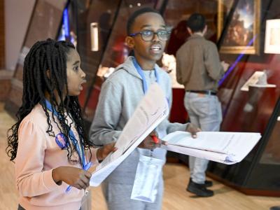 children holding maps in museum