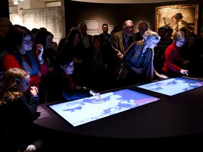People in exhibition looking at interactive maps