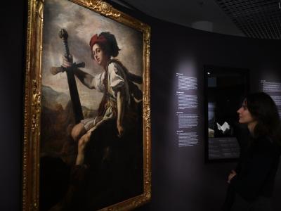 Woman in exhibition looking at painting