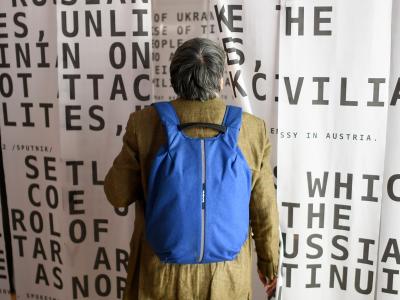 Person with backpack looking at propaganda wall
