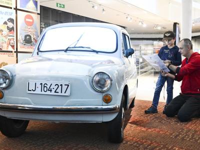 Man and child next to car in museum