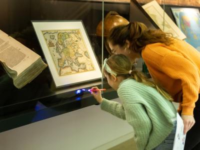 Child and woman looking at museum showcase