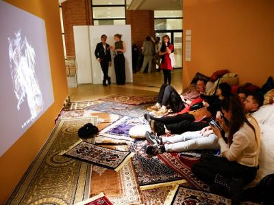 People in exhibition sitting on carpets