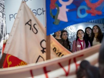 Women on guided tour in front of feminist flags