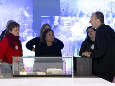 People on guided tour in front of euro currency display