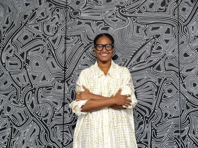 Woman standing in front of African art