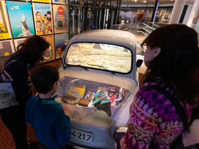 Family in front of car in museum