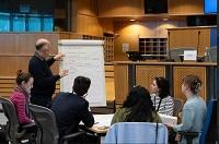 People discussing in front of white-board