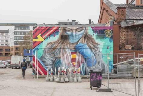 Colourful mural of super-nurse in mask