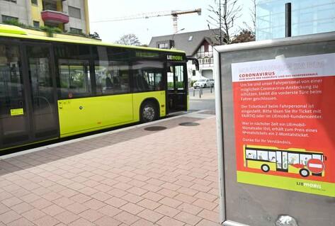 Yellow bus alongside poster with health measures