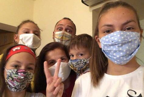 Family of parents and children wearing masks