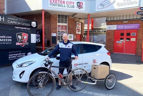 Man posing in front of car with bicycle