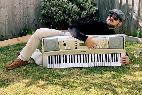 Man lying in garden next to keyboard