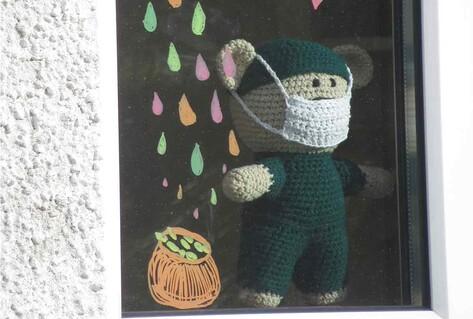 knitted leprechaun with mask in window