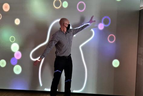 Man in front of interactive bubble shape on wall