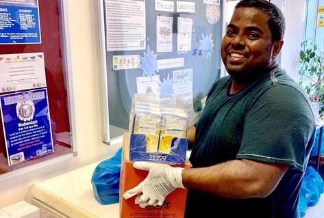 Man holding box of protective equipment and smiling