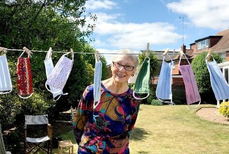 Woman in front of masks drying in garden
