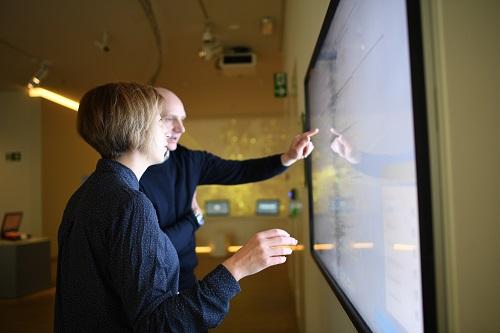 Two people using digital screen