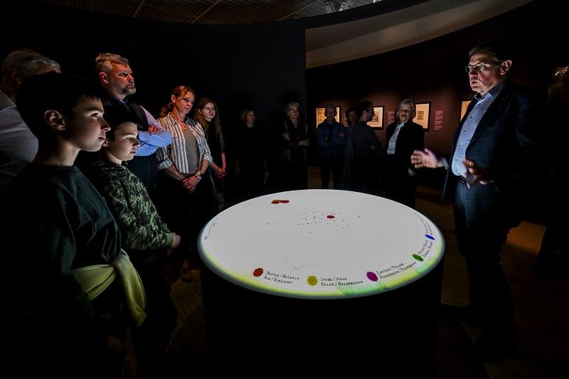 People in exhibition looking at interactive screen