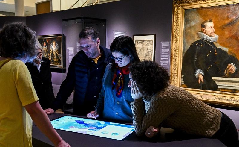 People in exhibition looking at interactive screen