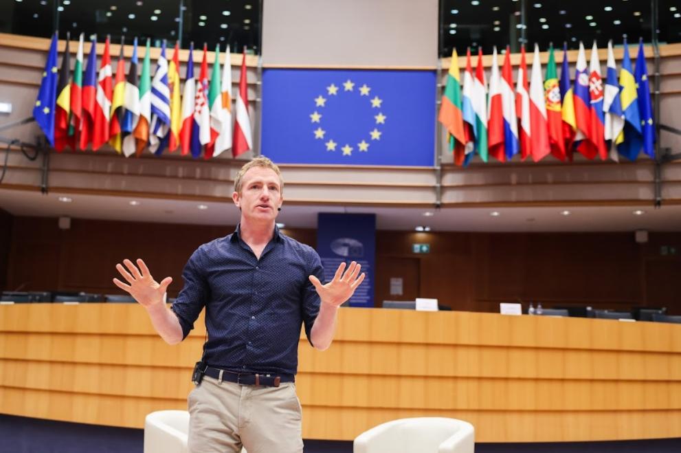 Man giving lecture in front of EU flag