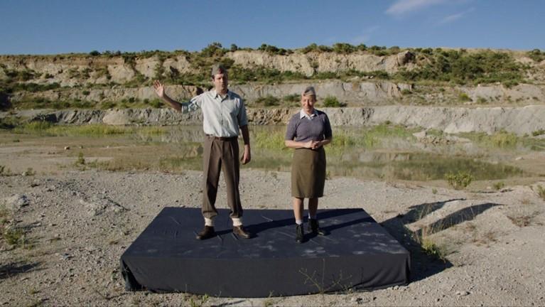 Man and woman in army clothes giving speech